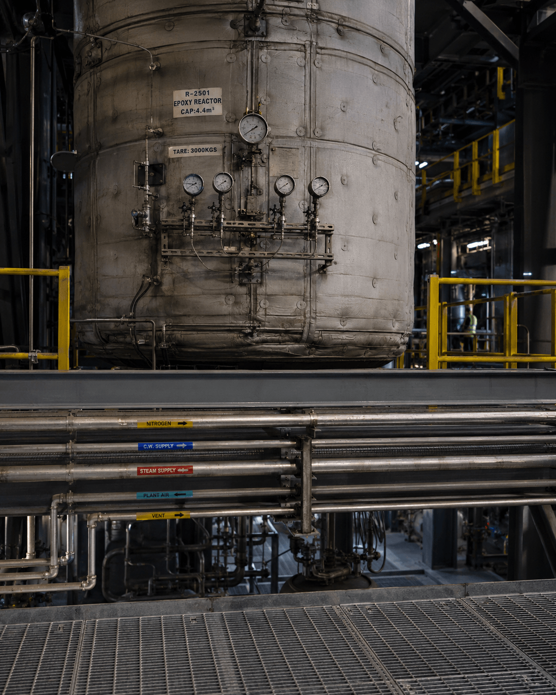 Epoxy reactor R-2501 with pressure gauge cluster and color-coded process piping (nitrogen, cooling water, steam, plant air, vent) in a chemical processing plant